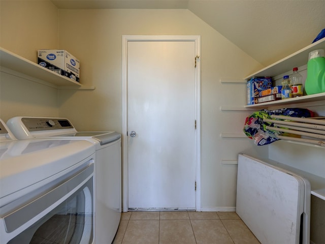 clothes washing area with washing machine and dryer and light tile patterned floors