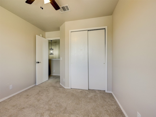 unfurnished bedroom with a closet, ceiling fan, and light carpet