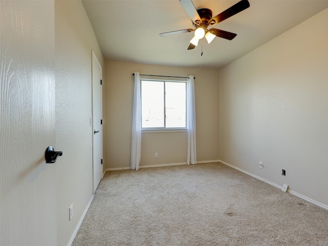 spare room featuring light colored carpet and ceiling fan