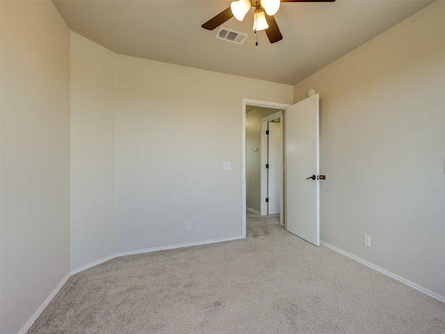 spare room featuring ceiling fan and light colored carpet