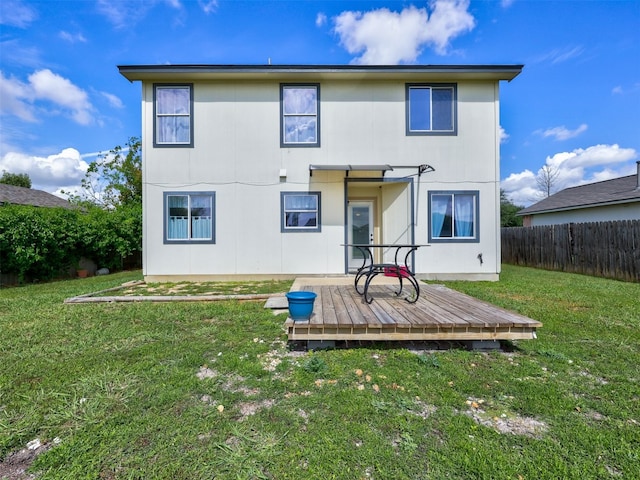 rear view of house with a deck and a yard