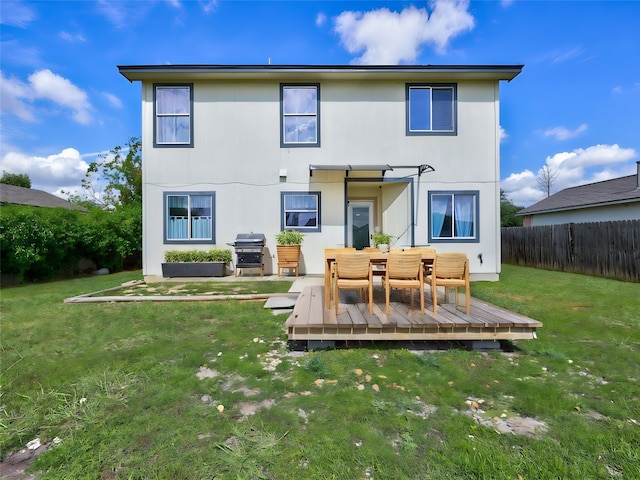 rear view of property with a yard and a deck