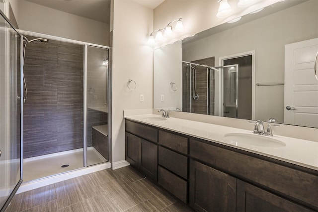 bathroom featuring a shower with door and vanity