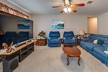 carpeted living room featuring ceiling fan