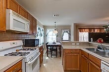 kitchen with sink, pendant lighting, and white appliances