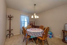 dining room with carpet and an inviting chandelier