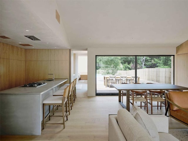 dining space featuring light hardwood / wood-style floors and wood walls