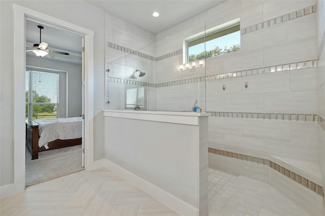 bathroom with a tile shower, a wealth of natural light, and ceiling fan