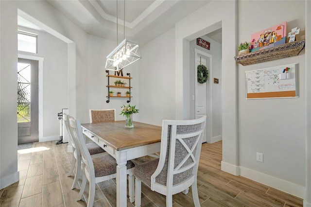 dining space featuring light hardwood / wood-style floors and a raised ceiling