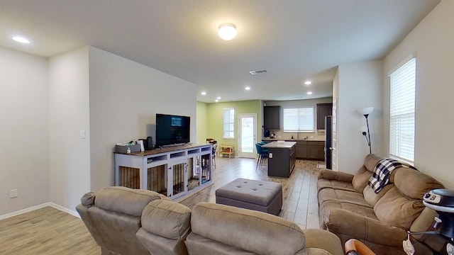 living room with a wealth of natural light and light hardwood / wood-style floors