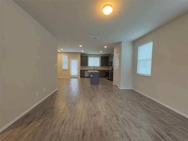 unfurnished living room featuring recessed lighting, visible vents, baseboards, and wood finished floors