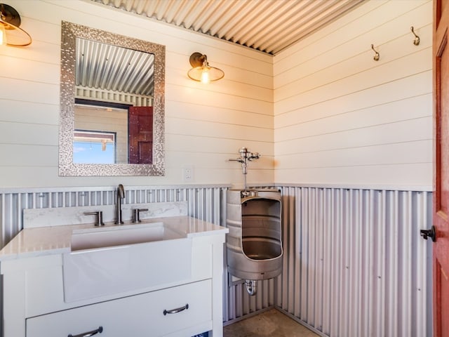 bathroom featuring vanity and wood walls