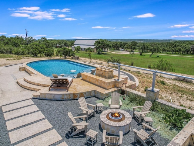 view of swimming pool featuring a patio and a fire pit