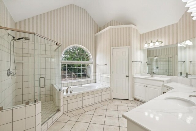 bathroom with dual vanity, tile patterned floors, vaulted ceiling, and independent shower and bath