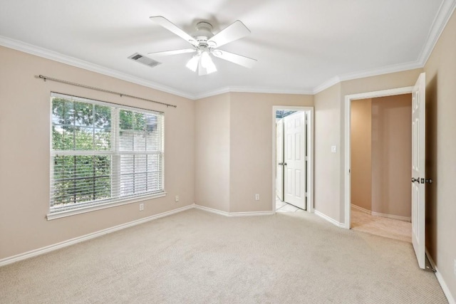 spare room with light carpet, crown molding, and ceiling fan