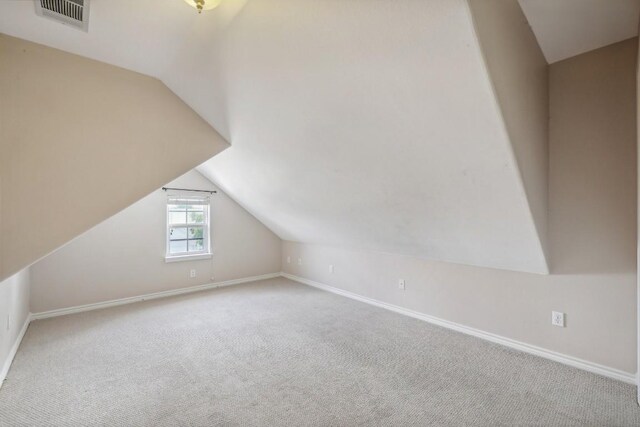 bonus room with carpet floors and vaulted ceiling