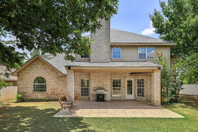 back of house with a patio area and a lawn