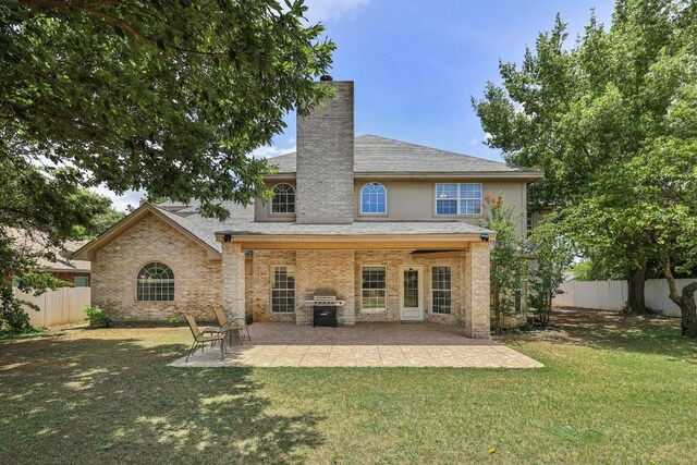 rear view of property with a lawn and a patio area