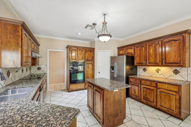 kitchen with decorative backsplash, light tile patterned flooring, decorative light fixtures, and a kitchen island