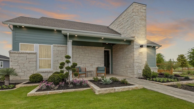 back house at dusk featuring a yard