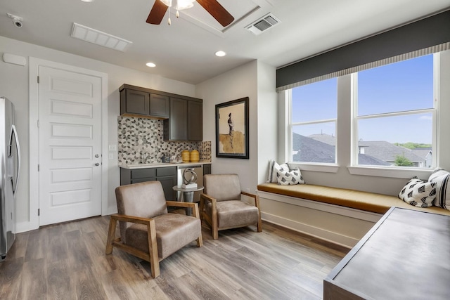 living area with ceiling fan, a mountain view, and light hardwood / wood-style flooring