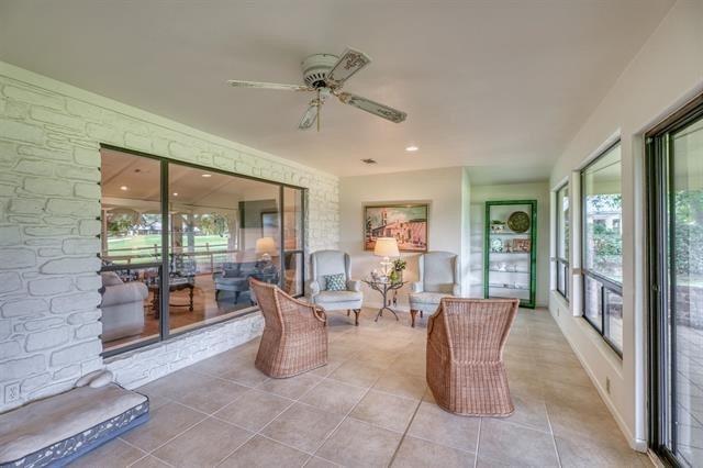 sunroom / solarium featuring ceiling fan