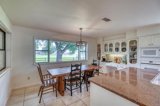 dining area with light tile patterned floors and a chandelier