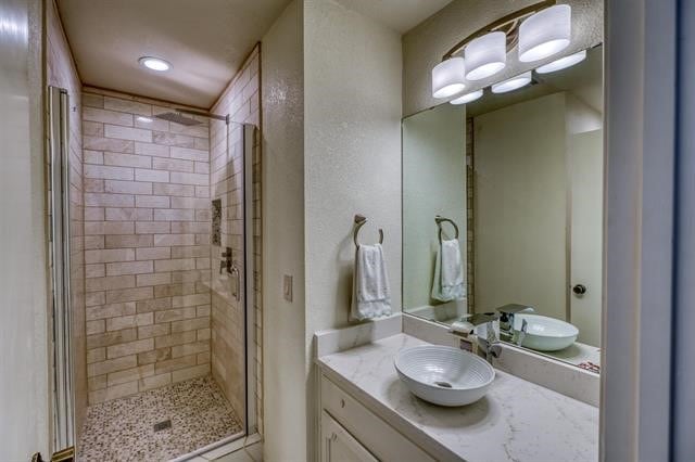 bathroom with vanity and a shower with door