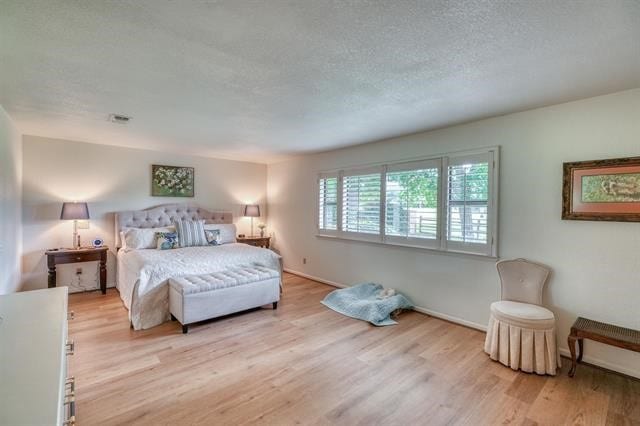 bedroom featuring light wood-type flooring and a textured ceiling