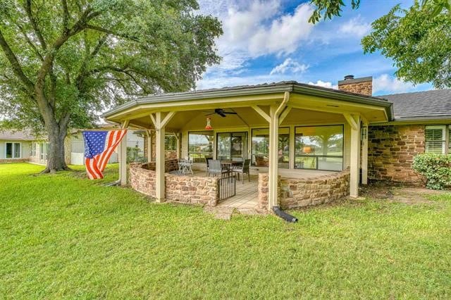 rear view of property featuring a patio, ceiling fan, and a lawn