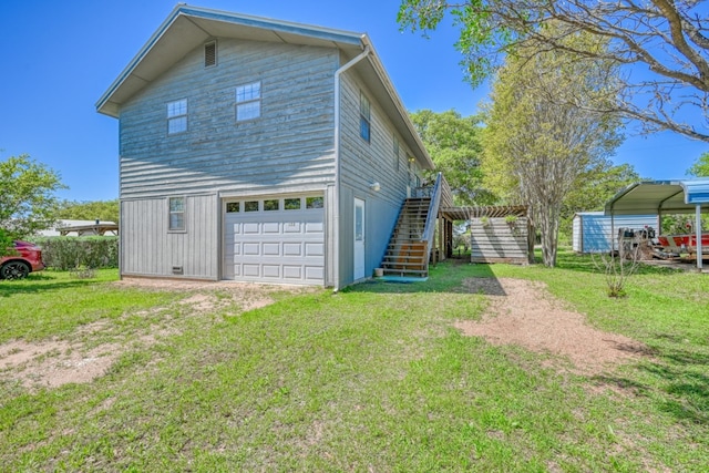 rear view of property with a garage, a yard, and a carport