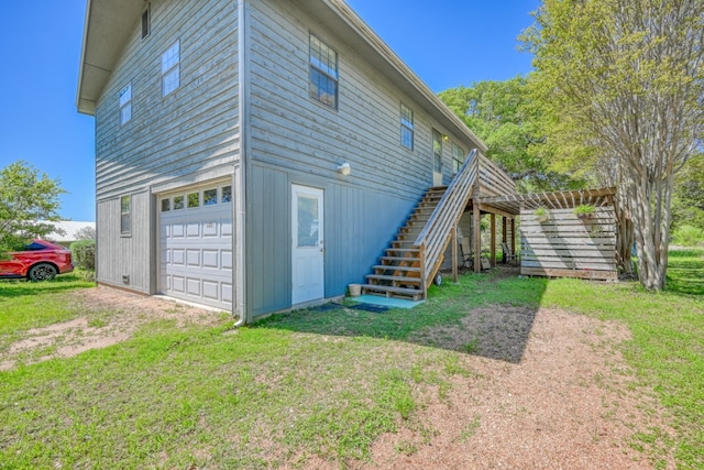 view of side of home featuring a garage and a yard