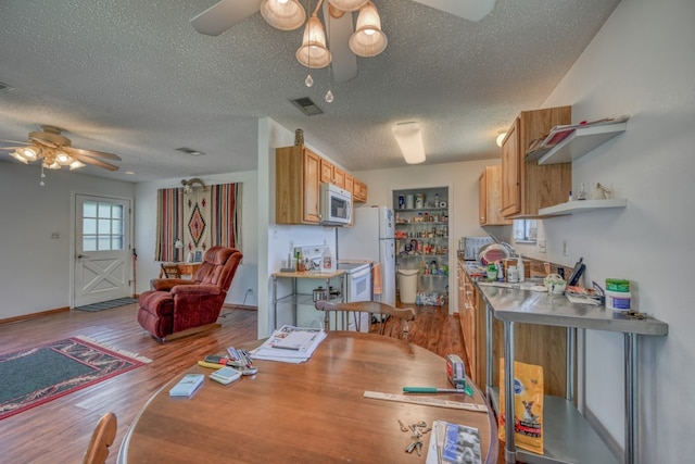 dining space featuring a textured ceiling, ceiling fan, and hardwood / wood-style flooring