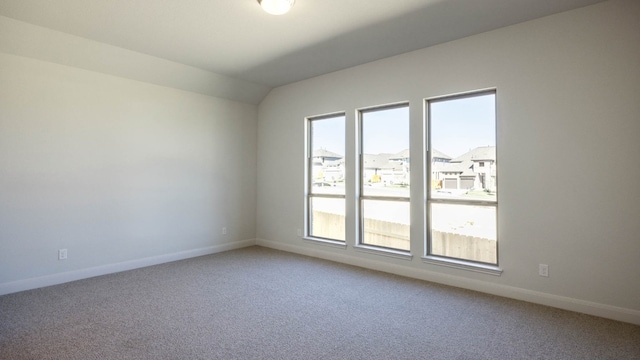 unfurnished room featuring carpet and lofted ceiling