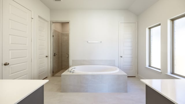 bathroom with vanity, lofted ceiling, independent shower and bath, and plenty of natural light