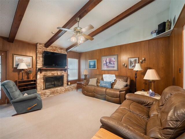 living room featuring carpet, a stone fireplace, wooden walls, and ceiling fan