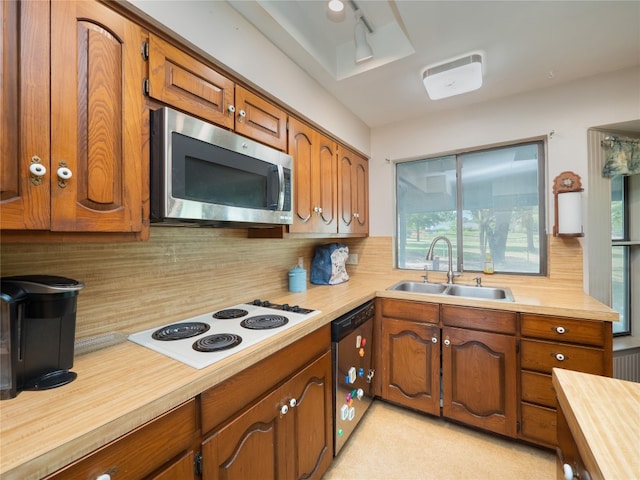 kitchen featuring sink, white gas stovetop, and tasteful backsplash