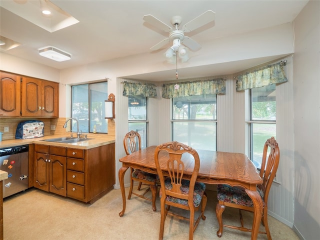 carpeted dining room with sink and ceiling fan