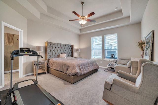 carpeted bedroom with ceiling fan and a raised ceiling