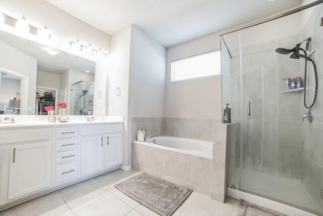 bathroom with tile patterned flooring, separate shower and tub, and dual vanity