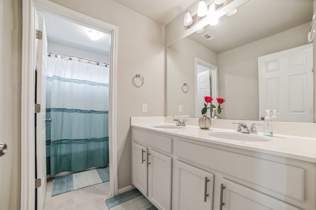 bathroom with double sink vanity and tile patterned flooring