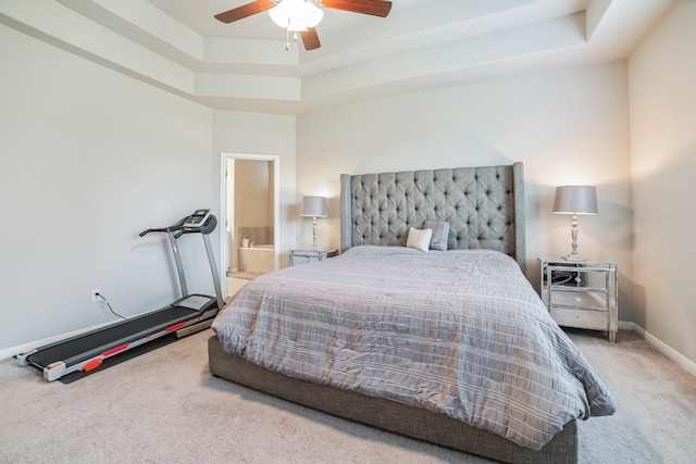 bedroom featuring carpet flooring, connected bathroom, a raised ceiling, and ceiling fan