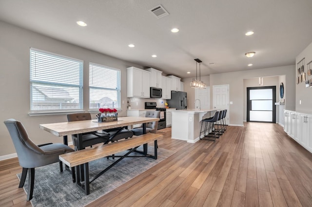 dining space with sink and hardwood / wood-style floors