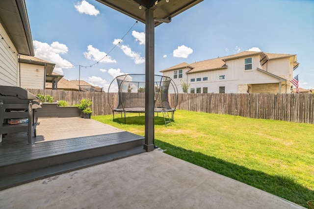 view of yard featuring a deck and a trampoline