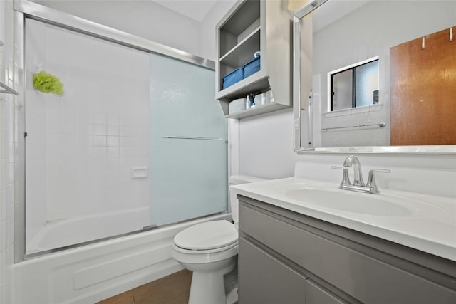 full bathroom with vanity, bath / shower combo with glass door, and toilet