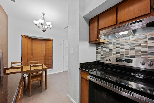 kitchen featuring tasteful backsplash, pendant lighting, stainless steel range with electric cooktop, and dark stone countertops