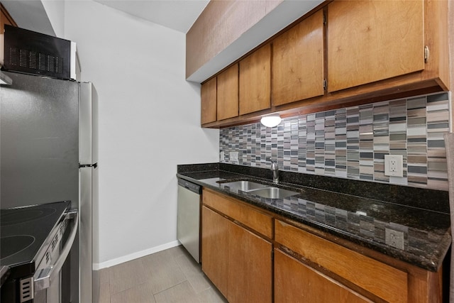 kitchen featuring tasteful backsplash, appliances with stainless steel finishes, sink, and dark stone counters