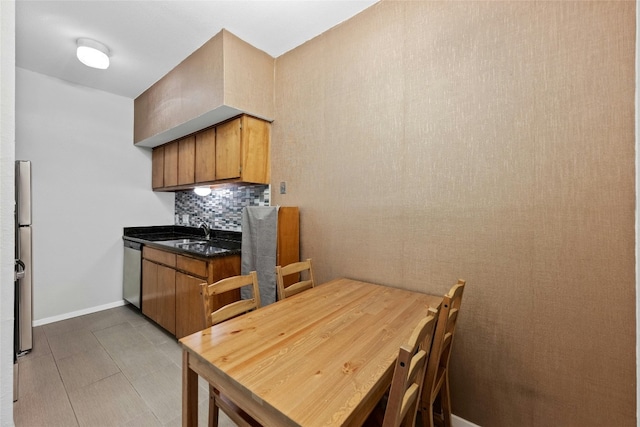 kitchen with stainless steel appliances, sink, light tile patterned floors, and backsplash