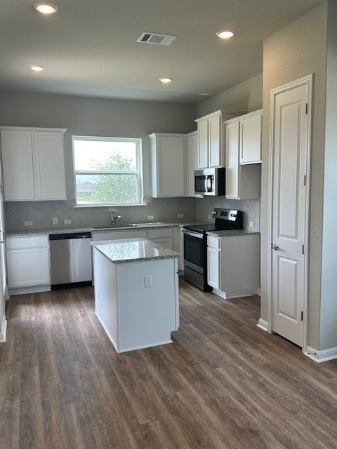 kitchen featuring appliances with stainless steel finishes, white cabinetry, and dark hardwood / wood-style floors