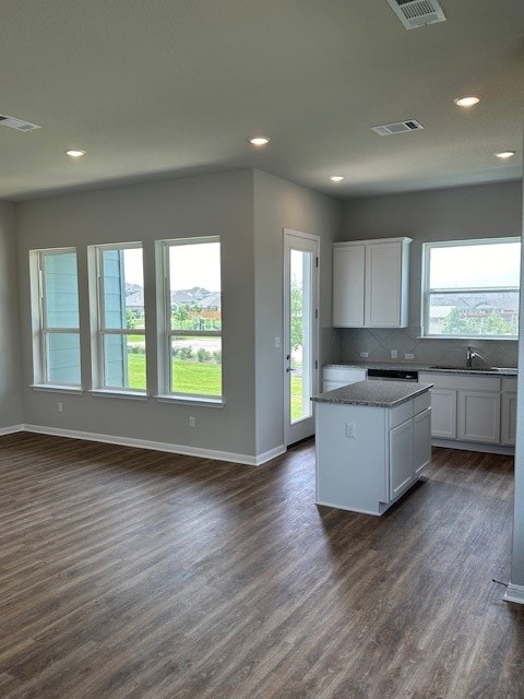 kitchen featuring a kitchen island, white cabinetry, dark hardwood / wood-style floors, and tasteful backsplash